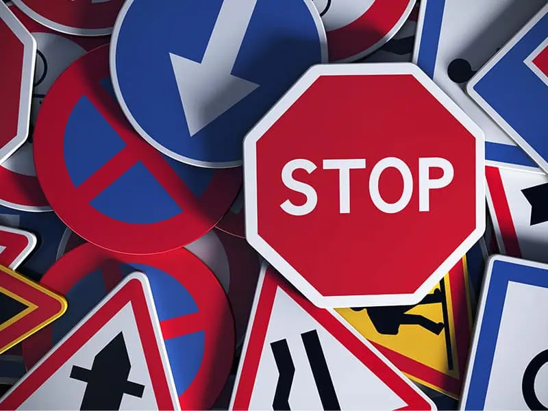 overhaed view of different directional signs for stop, safety or caution